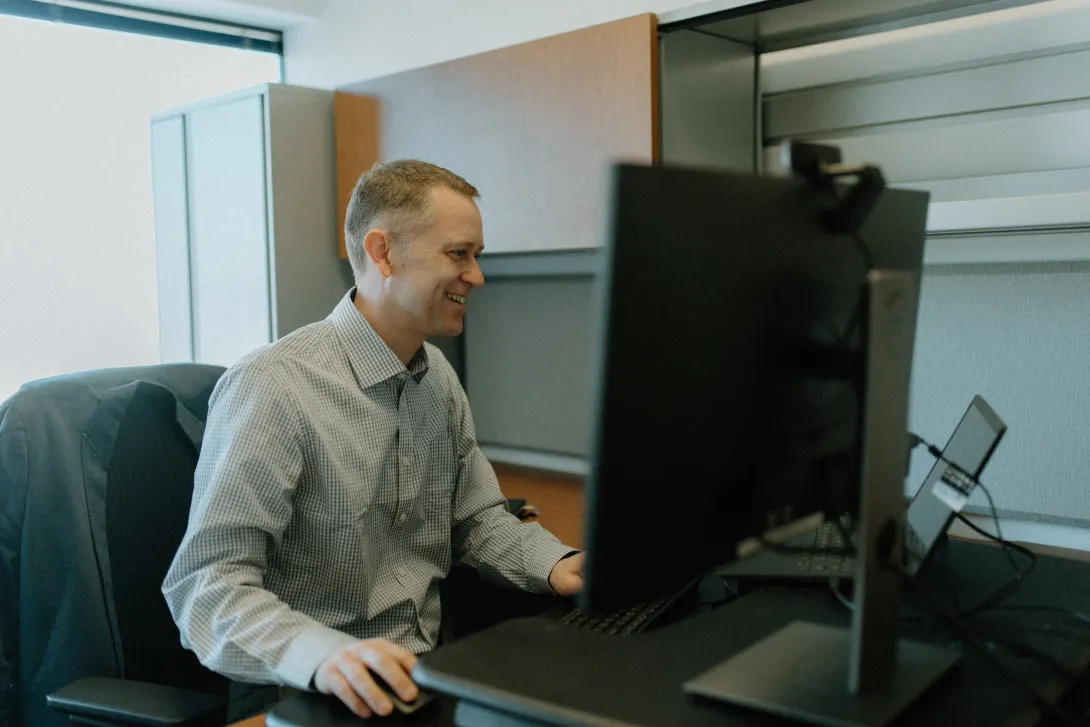 A male sitting behind a computer.